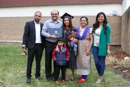 Proud graduate standing with family.
