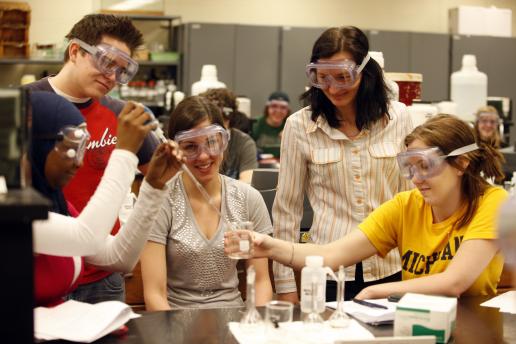 Students in safety goggles working in the lab