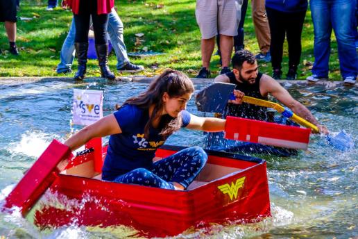 Students participating in boat races in Chancellor's Pond during homecoming