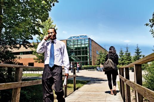 Students walking across wooden bridge on campus