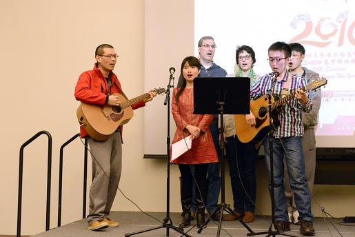 Students singing being lead by person playing the guitar