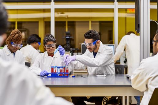 Students dressed in lab coats conducting experiments