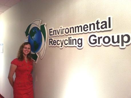 Crystal Edmonds stands in front of sign reading Environmental Recycling Group