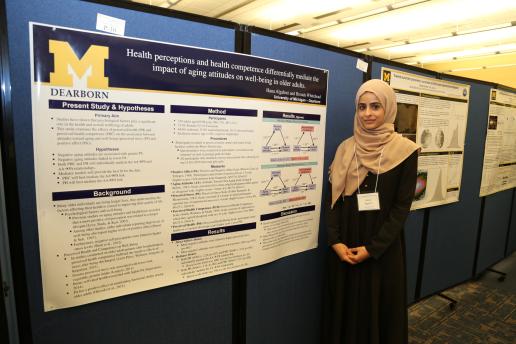 Student standing in front of her research poster.