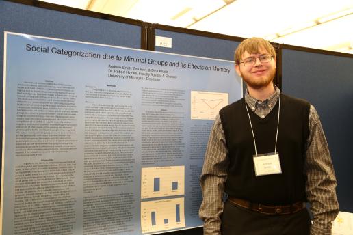 Student standing in front of his research poster.