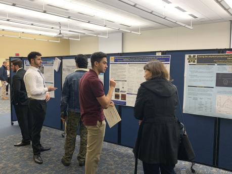 Research poster presentation. Student explaining his reasearch.