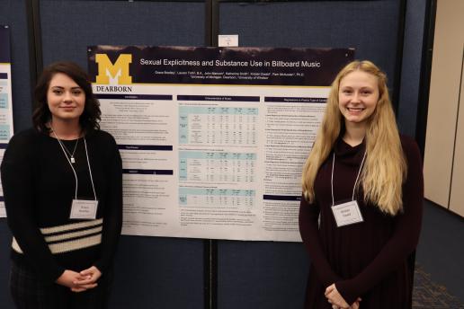 2 students standing in front of their research poster.