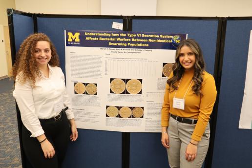 2 students standing in front of their research poster.