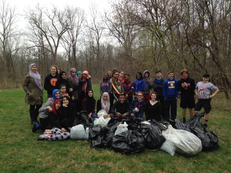 Edsel Ford High School student volunteers pull garlic and mustard from the environmental study area.