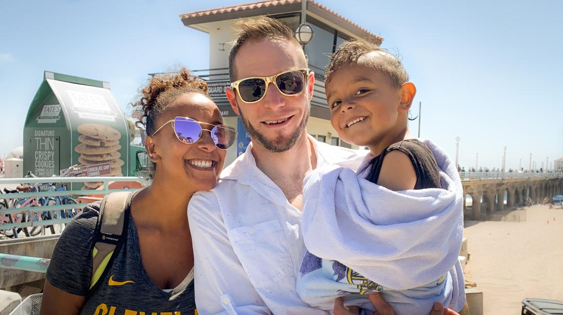 A family portrait of UM-Dearborn alum Austin Krauss with his wife, Meagan, and their 4-year-old son Xavier at the beach.