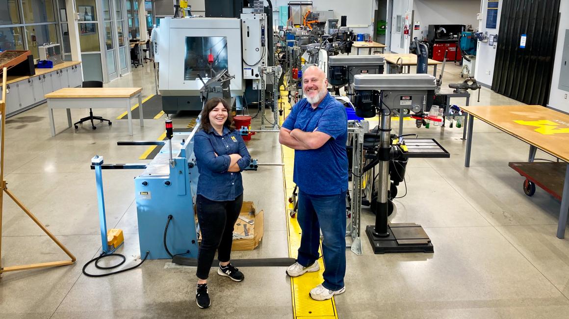MSEL staff Monica Somand and Shawn Simone stand in front of the equipment in the Manufacturing Systems Engineering Lab