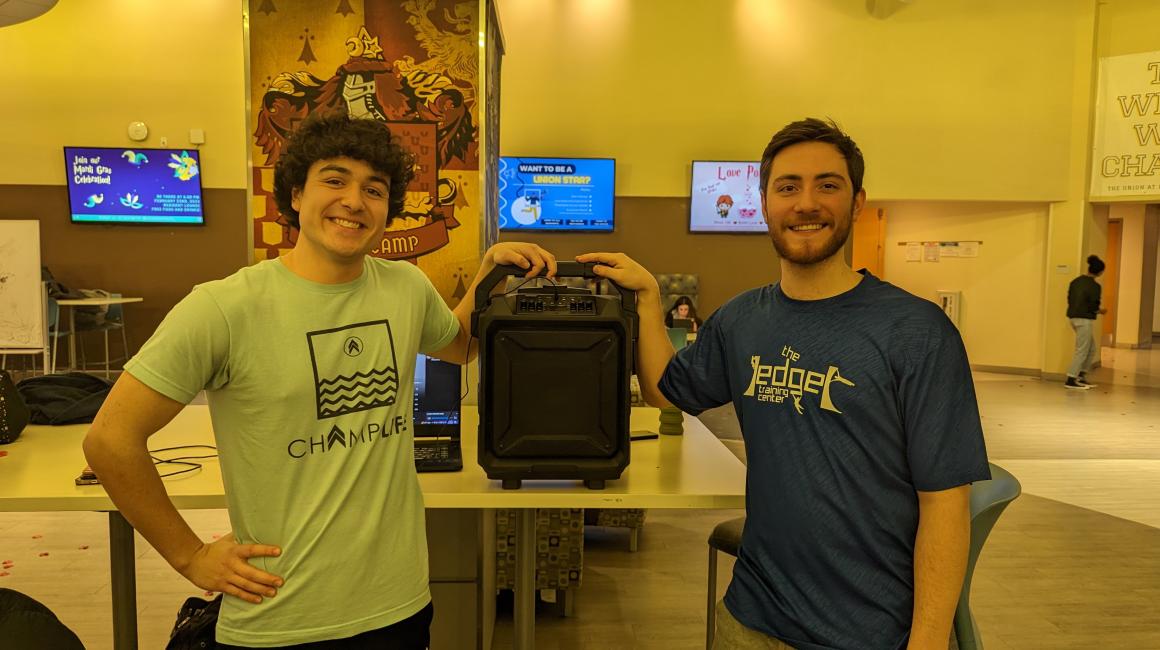 Photo of two students in front of a large speaker at a Swing Dearborn event