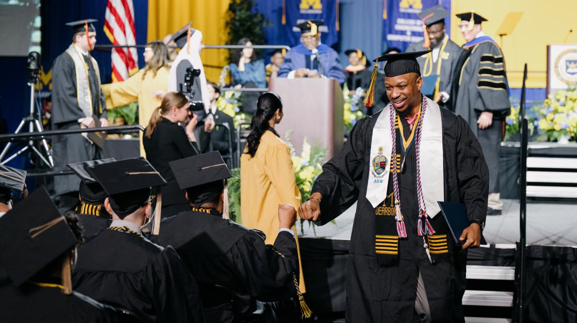 Photo of a student giving a fist pound at Spring '23 commencement
