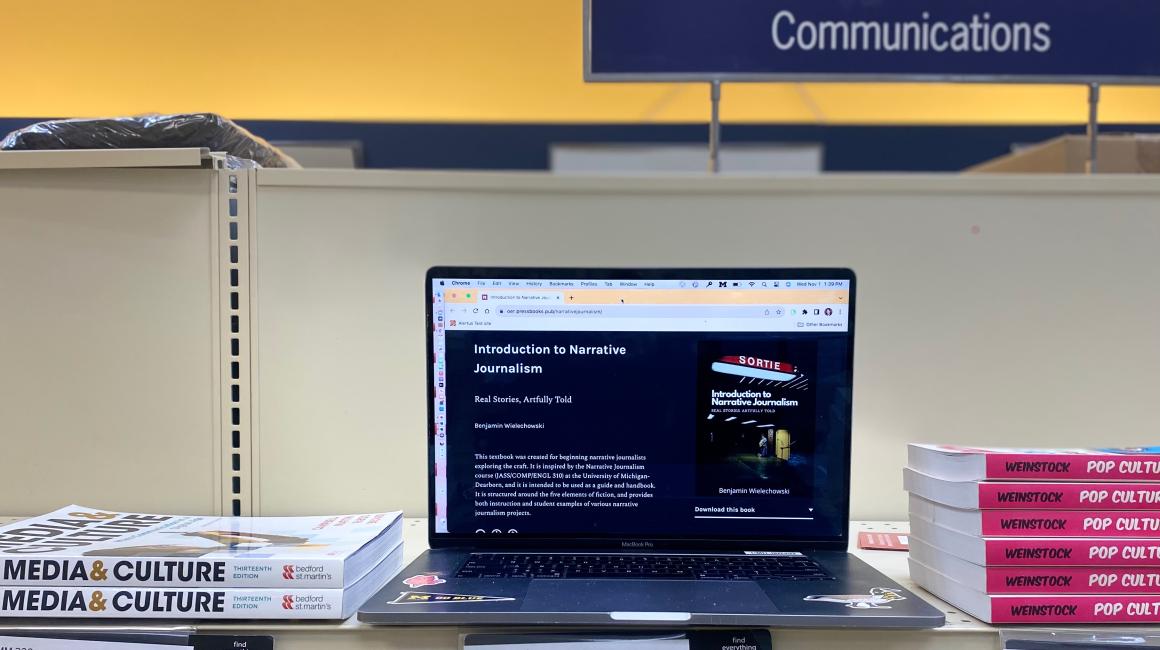 Photo of OE Communications e-book on shelf with more traditional books