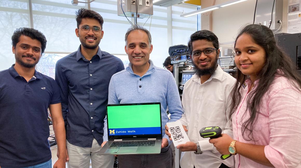 Electrical and Computer Engineering Professor Hafiz Malik (center) and his graduate students (from left) Aditya Bendale, Abhishek Ashok Borde, Abdul Kareem Shaik and Swetha Rani Kasimalla show off their name reader they created for Fall 2023 Commencement. 