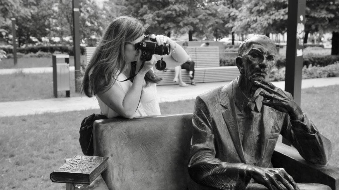 Beth Lundy taking a photo of a statute in Poland