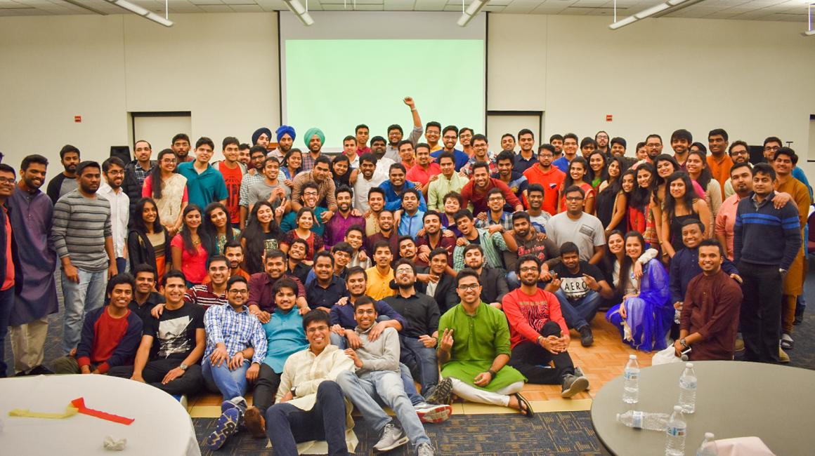 A large group of more than 100 students who are a part of the Indian Graduate Student Association at a mixer party.