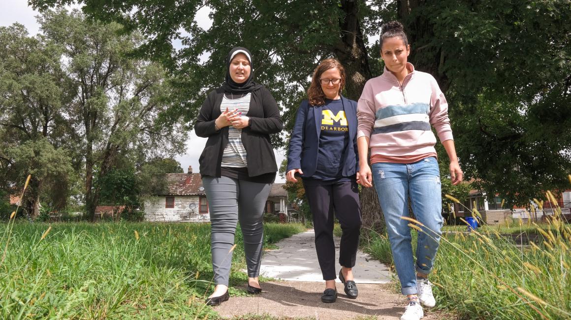 Assistant Professor OF Public Health Natalie Sampson (center) walks with senior Valeria Cossyleon (right) and Janine Hussein (‘18), two UM-Dearborn students who helped collect door-to-door health surveys. 