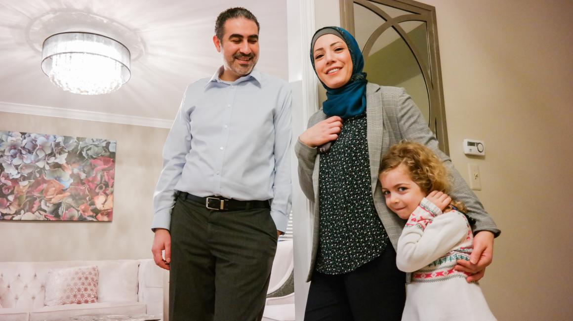 Ahmad MK Nasser is a middle-aged Arab man. He stands with his wife, Batoul Abdallah, a middle-aged Arab woman with a hijab; and their daughter Dalia, a young, blonde curly-haired girl.