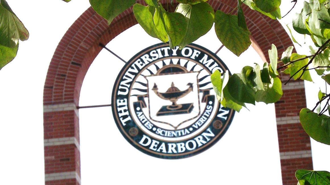 A shot of the arch with the UM-Dearborn seal outside of the Social Sciences building. The seal reads “The University of Michigan” “Dearborn” on the outer circle and the inner circle reads “Artes - Scientia - Veritas”