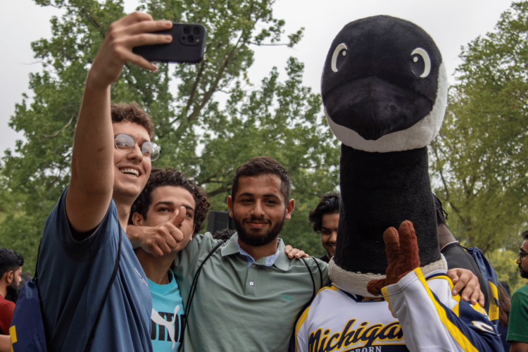 Students pose for a photo with Bruce the Goose at Wolverine Welcome Day. 