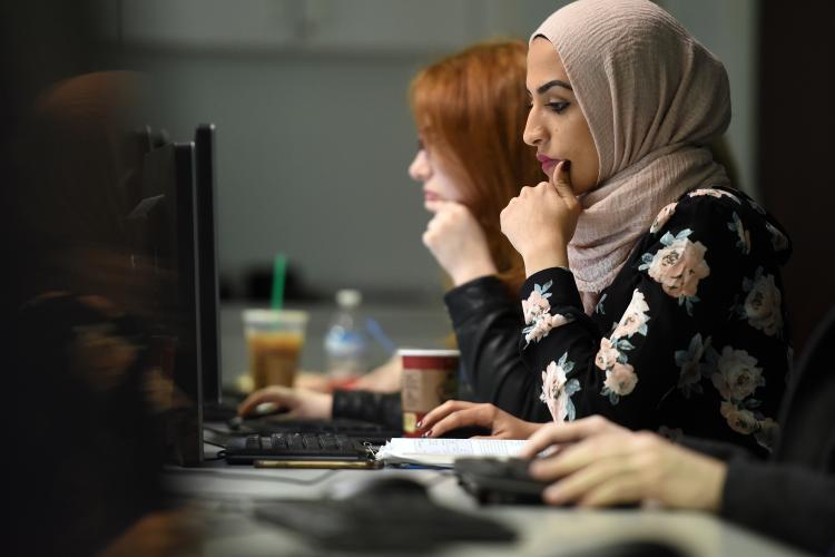 Two women intently looking at computer screens