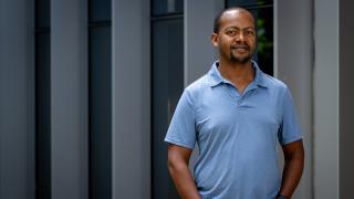 Associate Professor Birhanu Eshete stands for a portrait against a neutral background