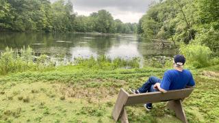 Photo of EIC Natural Areas Manager Rick Simek sitting on the south edge of Fair Lane Lake