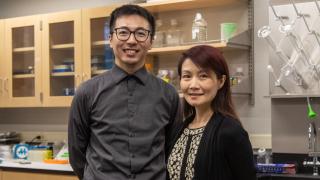 Assistant Professor Jie Fan and Associate Professor Dr. Zhi "Elena" Zhang stand for a portrait in their biology lab