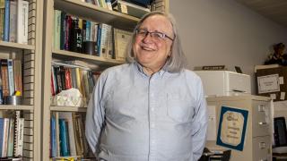 Professor Bruce Maxim stands in his office.