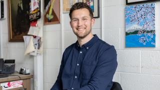 In his classroom at Oak Park middle school, Jesse Whitman poses for a seated portrait.