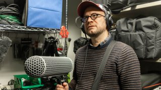 Man in glasses holding boom microphone