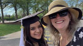 Photo of Student Affairs Assistant Director Kris Day, pictured right with woman in graduation cap and gown.